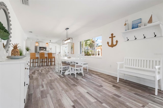 unfurnished dining area with light wood finished floors, visible vents, and baseboards