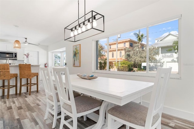 dining area featuring light wood-style floors and baseboards