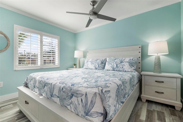 bedroom with a ceiling fan, crown molding, baseboards, and wood finished floors