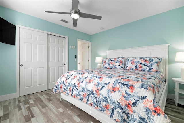 bedroom with a ceiling fan, visible vents, baseboards, light wood-style flooring, and a closet