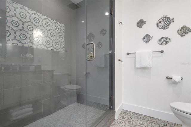 bathroom featuring baseboards, toilet, a stall shower, and tile patterned flooring