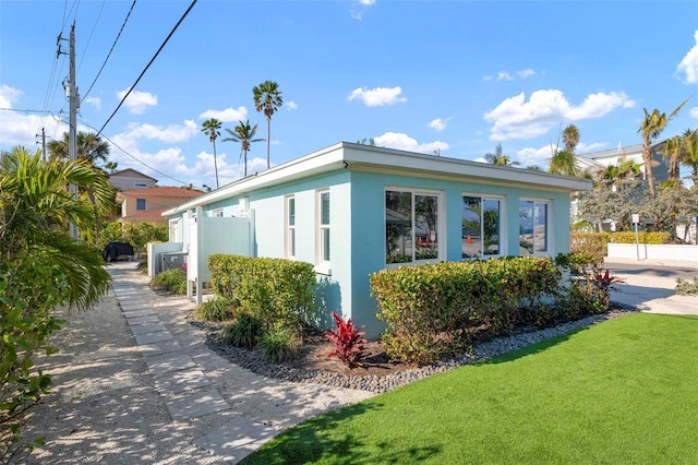 view of home's exterior featuring stucco siding, a yard, and fence