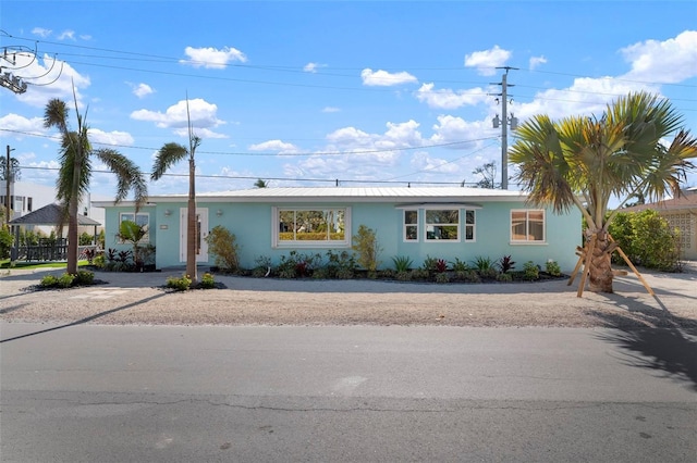 single story home featuring a gazebo, metal roof, and stucco siding