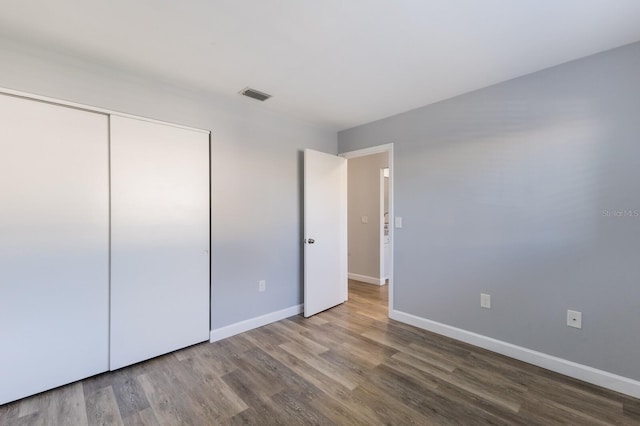 unfurnished bedroom with hardwood / wood-style flooring and a closet