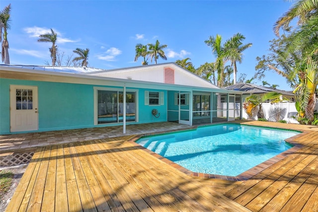 view of pool featuring a deck, a sunroom, fence, and a fenced in pool