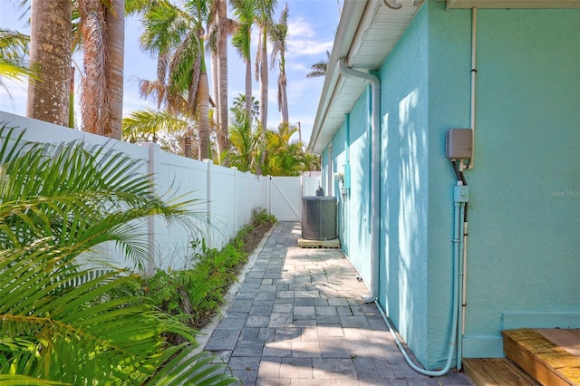 view of home's exterior with central AC unit, a patio area, a fenced backyard, and stucco siding