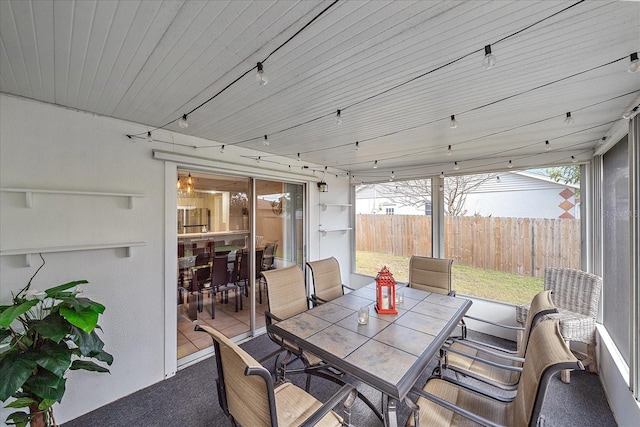 sunroom / solarium featuring rail lighting