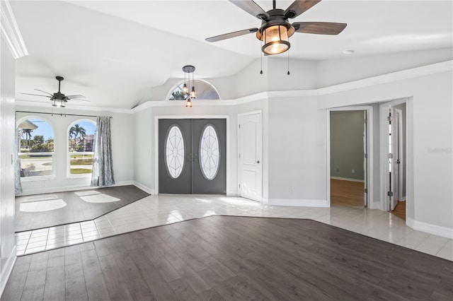 foyer featuring ceiling fan with notable chandelier, wood finished floors, french doors, baseboards, and vaulted ceiling