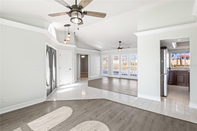 empty room with wood finished floors, a healthy amount of sunlight, lofted ceiling, and a sink