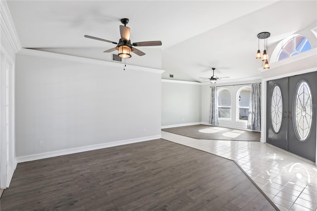 foyer entrance with baseboards, lofted ceiling, ornamental molding, french doors, and wood finished floors