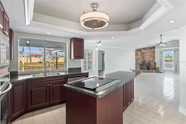 kitchen with a raised ceiling, dark countertops, and a sink