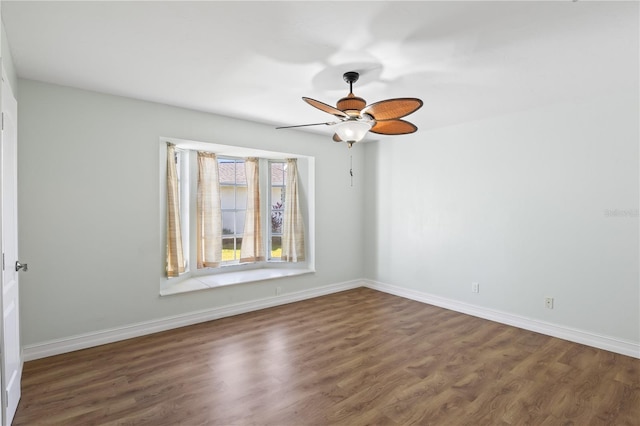 empty room featuring wood finished floors, baseboards, and ceiling fan