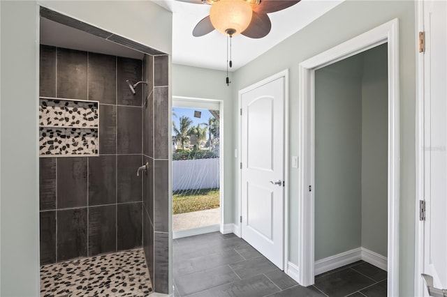 bathroom featuring baseboards, tiled shower, and ceiling fan