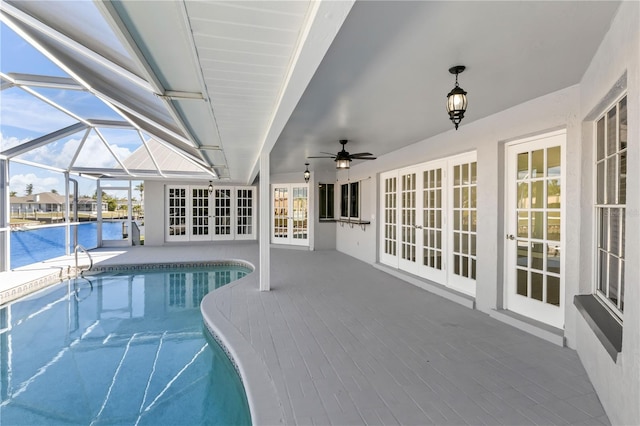 outdoor pool with french doors, a patio, glass enclosure, and a ceiling fan