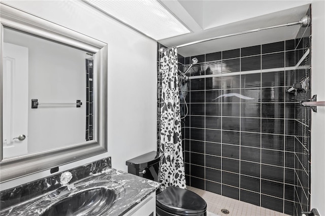 bathroom with vanity, toilet, and tiled shower