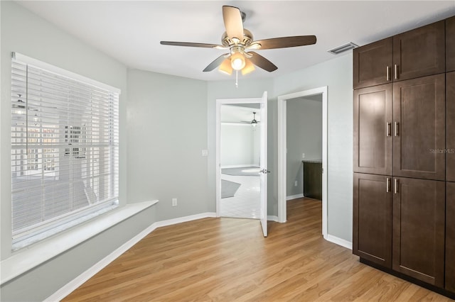 unfurnished bedroom with visible vents, baseboards, light wood-style flooring, a closet, and a ceiling fan