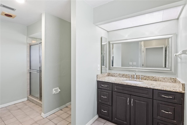 full bath with vanity, a shower stall, baseboards, and visible vents