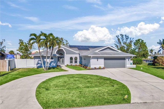 ranch-style home featuring fence, driveway, solar panels, a front lawn, and a garage