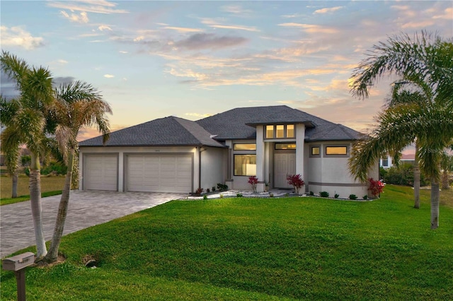 prairie-style home with a garage and a lawn