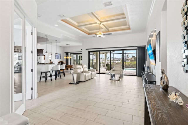 living room with coffered ceiling, a towering ceiling, crown molding, and ceiling fan