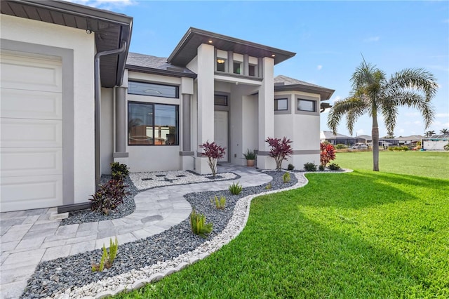 entrance to property featuring a yard and a garage