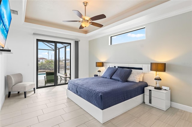 bedroom with a tray ceiling, access to outside, and ceiling fan