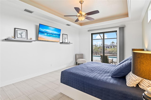 bedroom with ceiling fan, ornamental molding, and a tray ceiling