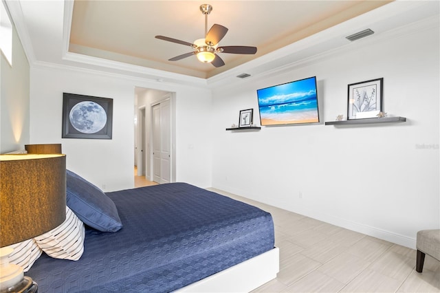 bedroom featuring a tray ceiling, ornamental molding, and ceiling fan