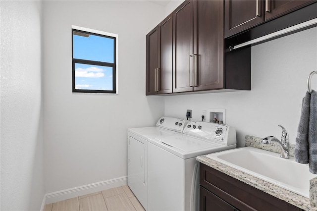 laundry room with sink, washer and clothes dryer, and cabinets