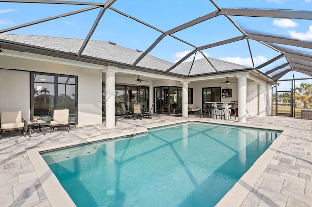 view of swimming pool featuring a lanai, a patio area, ceiling fan, and a bar