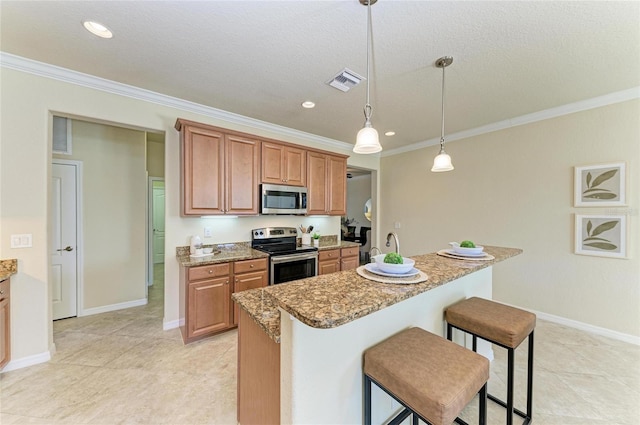 kitchen with appliances with stainless steel finishes, a kitchen island, light stone countertops, a kitchen bar, and decorative light fixtures