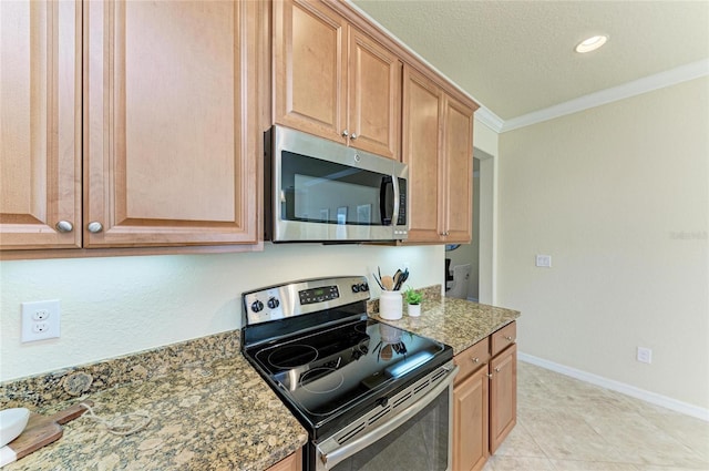 kitchen featuring light tile patterned floors, crown molding, appliances with stainless steel finishes, a textured ceiling, and dark stone counters