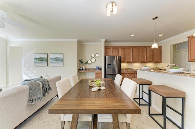 tiled dining area featuring ornamental molding and ceiling fan