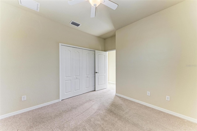 unfurnished bedroom featuring ceiling fan, a closet, and light carpet