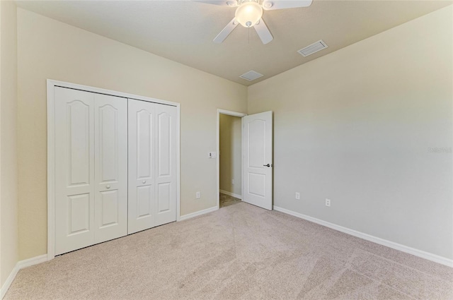 unfurnished bedroom featuring light carpet, ceiling fan, and a closet