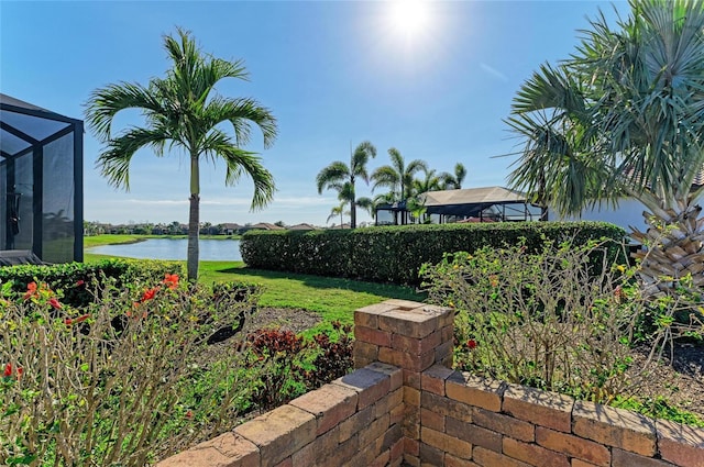 view of yard with a water view and a lanai