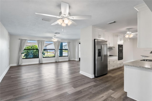 kitchen with visible vents, open floor plan, white cabinets, a sink, and black appliances