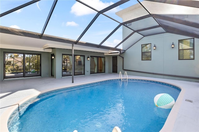 outdoor pool featuring glass enclosure and a patio area