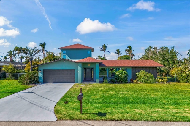 view of front of property with a garage, a front yard, and driveway