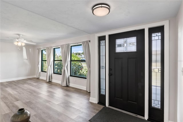 entryway featuring ceiling fan, baseboards, and wood finished floors