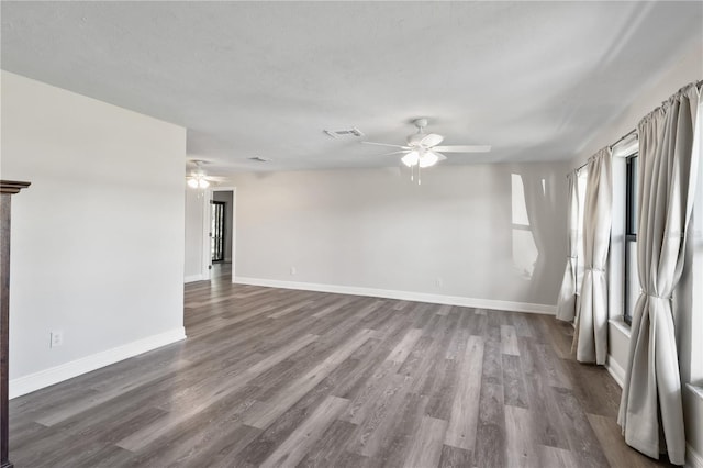 spare room featuring a ceiling fan, visible vents, and wood finished floors