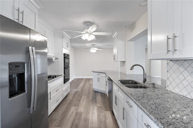 kitchen with black appliances, a sink, light stone countertops, and white cabinets