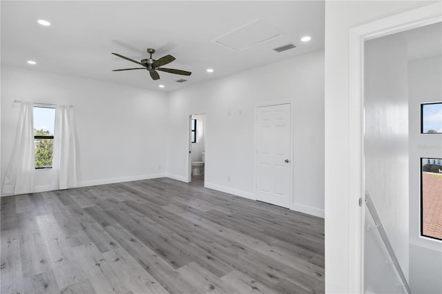 spare room with light wood-style floors, recessed lighting, visible vents, and attic access