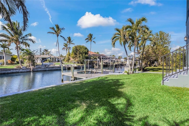 view of dock with a water view and a lawn