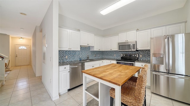 7632 Plantation Cir, Bradenton, FL 34201 - kitchen with appliances with stainless steel finishes, a sink, backsplash, and light tile patterned floors
