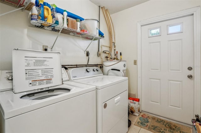 laundry area with light tile patterned floors, washing machine and dryer, and electric water heater