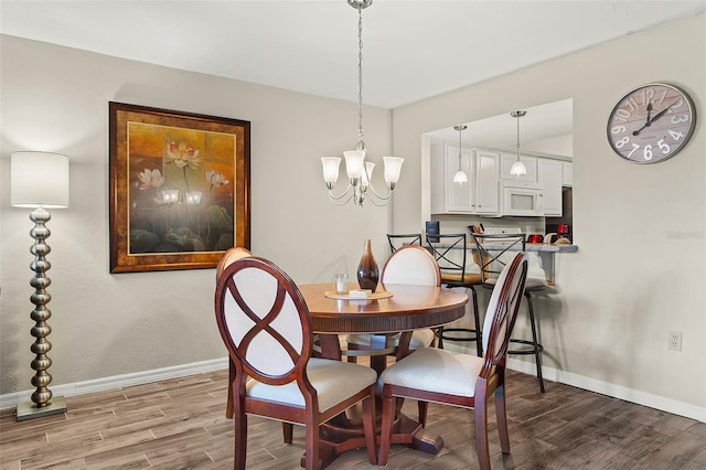 dining room featuring hardwood / wood-style floors and a notable chandelier