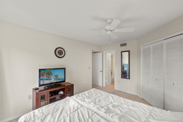 bedroom featuring light carpet, ceiling fan, and a closet