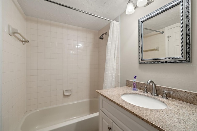 bathroom with vanity, shower / bathtub combination with curtain, and a textured ceiling