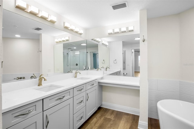 bathroom with wood-type flooring, separate shower and tub, and vanity